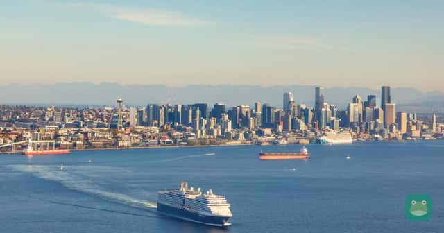A cruise ship in Elliott Bay with the Seattle skyline behind